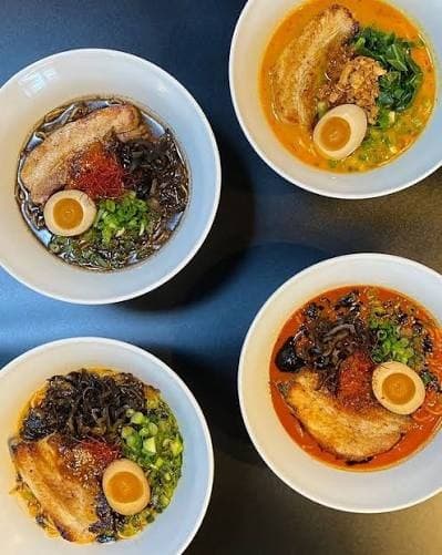 Four ramen bowls seen from above, with chashu, egg, and greens