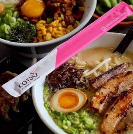 Ramen bowls and gyoza on a table with chopsticks